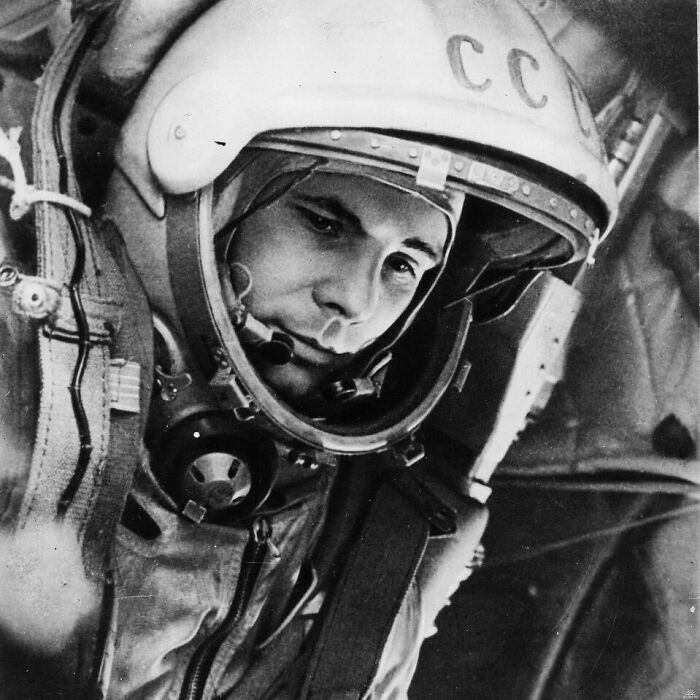 Astronaut in a space helmet, focused and poised in a spacecraft cockpit, embodying historical moments from the past.