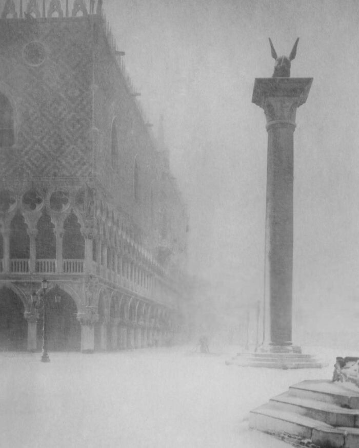 Historic scene of a foggy day in Venice with architectural details and a column visible, evoking a sense of nostalgia.