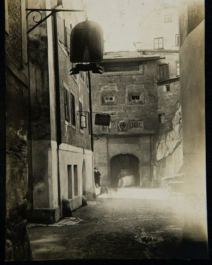 Historical street scene with vintage buildings casting shadows, invoking nostalgia.