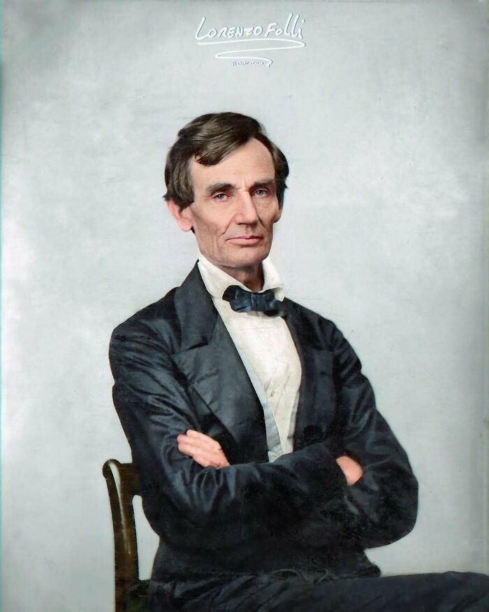A historical figure in a formal suit, seated with arms crossed, representing an iconic moment from the past.