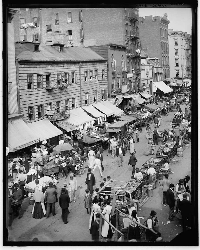 Historical city street market bustling with people and carts, evoking nostalgia with its old-world charm and activity.