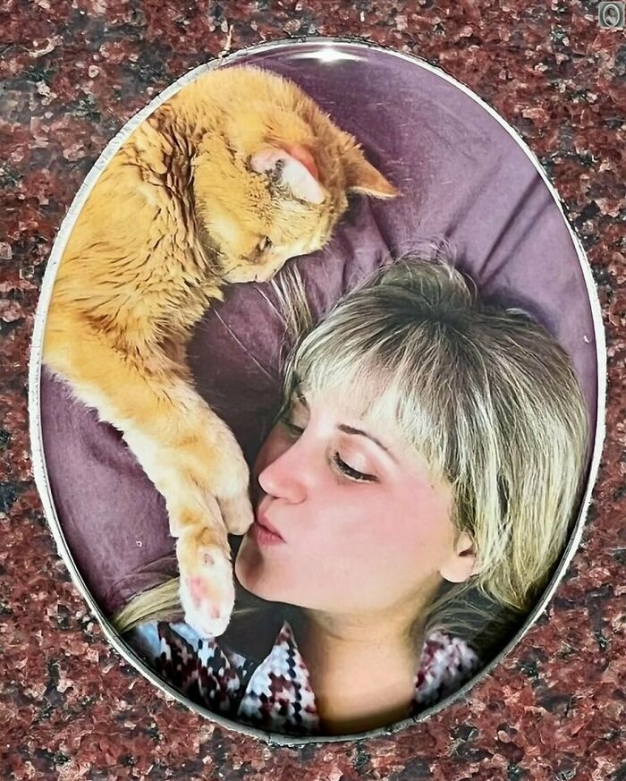 A lovely headstone portrait of a woman and a cat lying close together on a pillow.