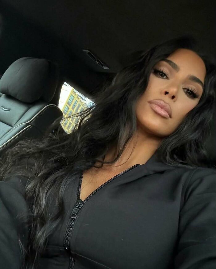 Celebrity taking a selfie in a car, emphasizing pettiness with a confident expression.