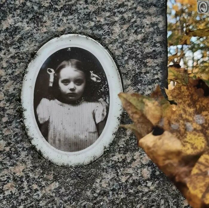 Elegant headstone portrait of a young girl, with autumn leaves in the foreground.
