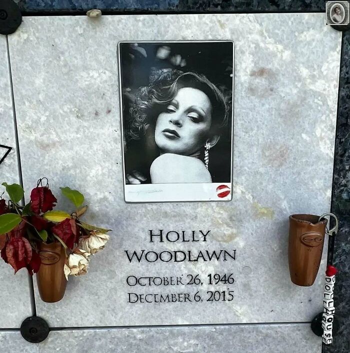 Headstone portrait with a classic black-and-white photo, adorned with flowers and memorial details.