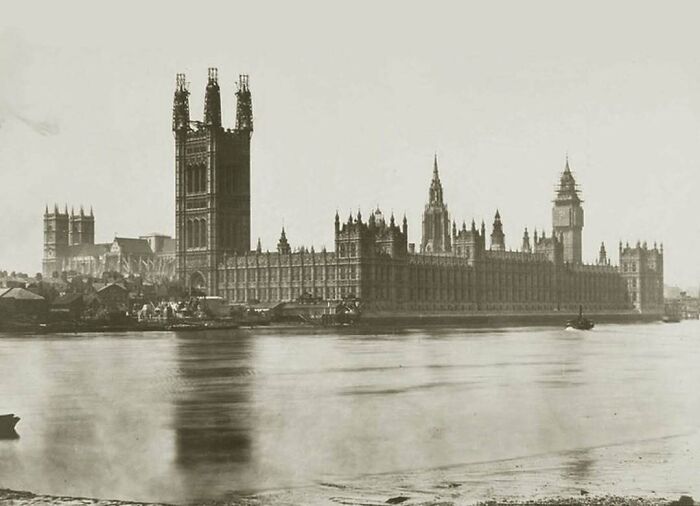 Historical pic of the Houses of Parliament by the river, featuring iconic architecture and a nostalgic atmosphere.