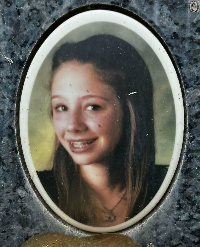 Young girl smiling in an oval headstone portrait, capturing a lovely and timeless memory.