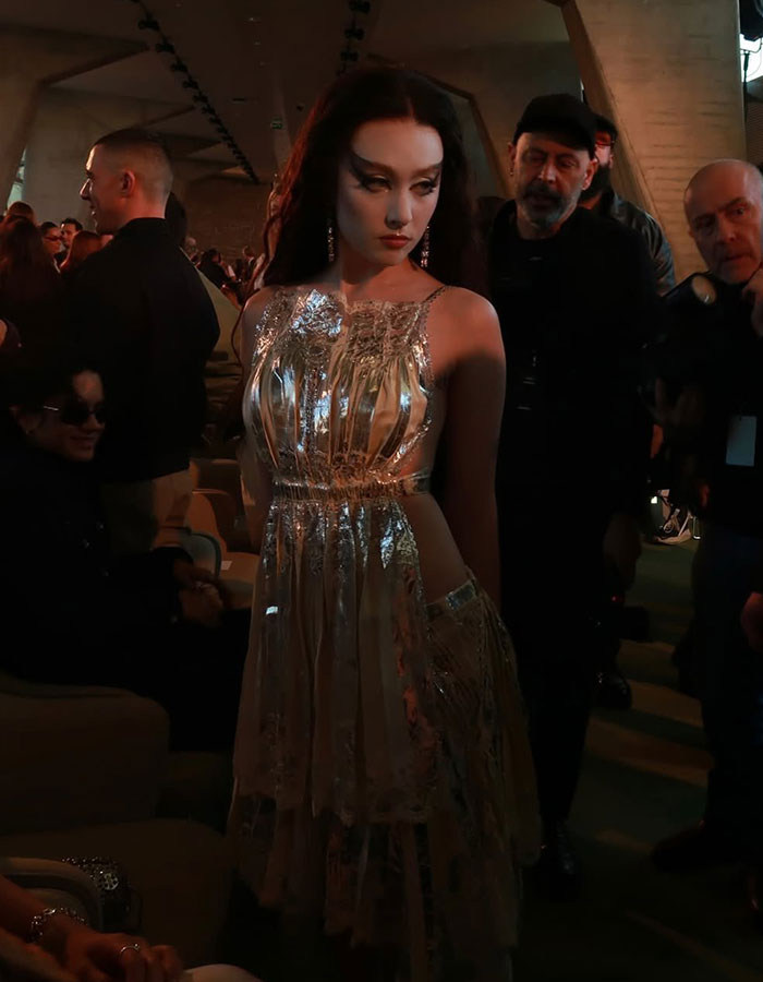 Chappell Roan at Paris Fashion Week, wearing a shimmering dress amid a crowd, sparking debate over her look.