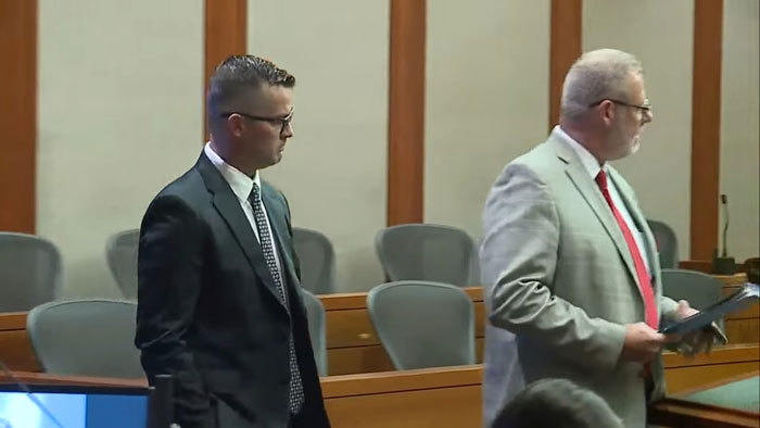Man in a courtroom during legal proceedings related to a neglect case involving a child in a hot car.