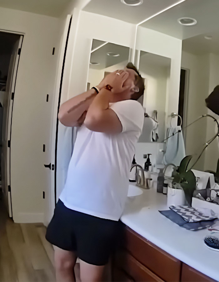 Man distressed, facing mirror in bathroom; related to plea deal rejection in hot car case.