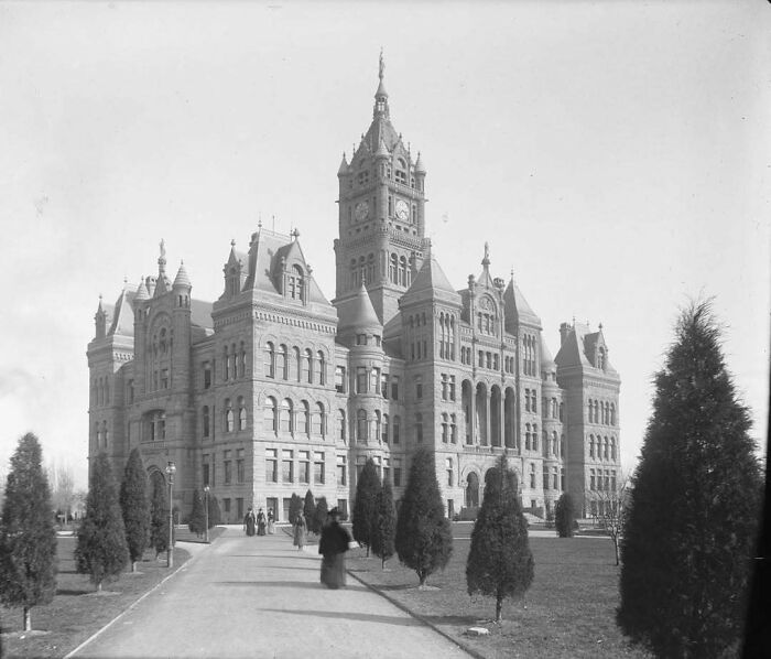 Grand historic building with a central clock tower, showcasing stunning old American architecture.