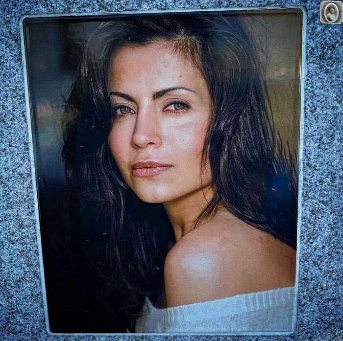 A lovely headstone portrait of a woman with long dark hair, looking softly into the distance.
