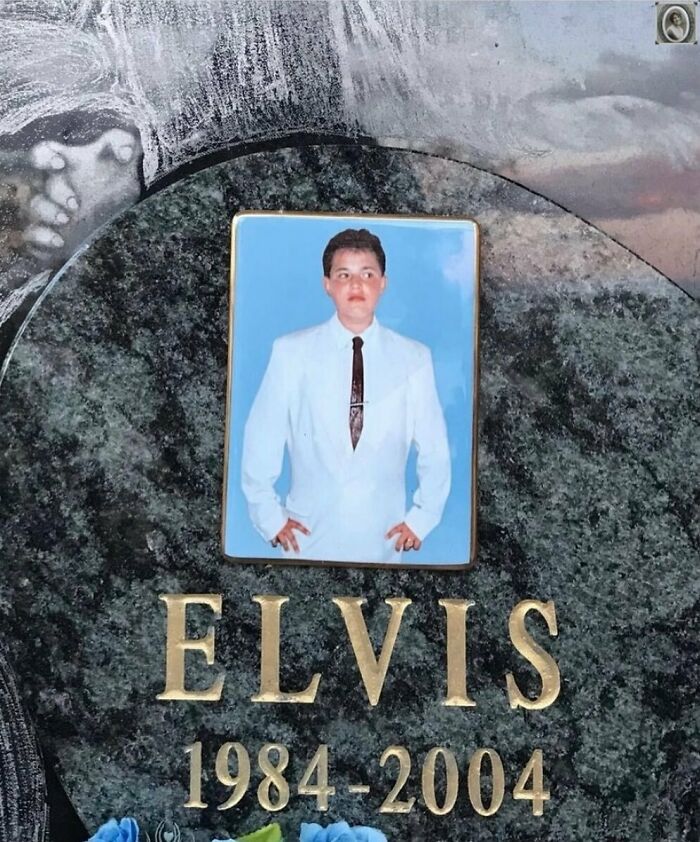 Portrait of a man in a white suit on a headstone, with "Elvis 1984-2004" engraved.