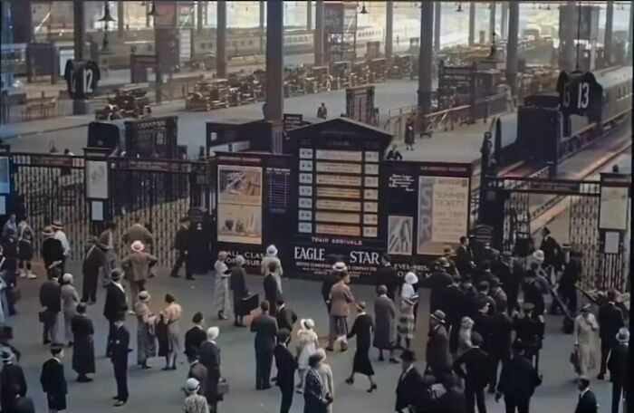 Historical pic of a busy vintage train station with people in period attire, evoking nostalgia.