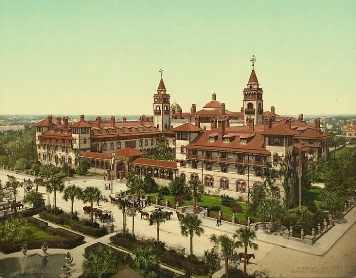 Historic American architecture with red roofs and palm-lined streets in a lush landscape.