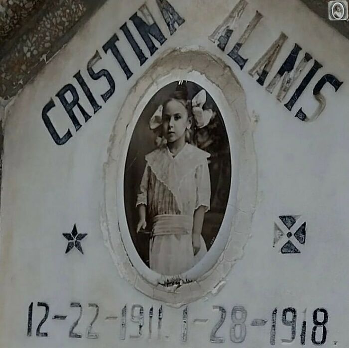 Vintage headstone portrait of a young girl, capturing a lovely memorial image with her name and dates engraved.