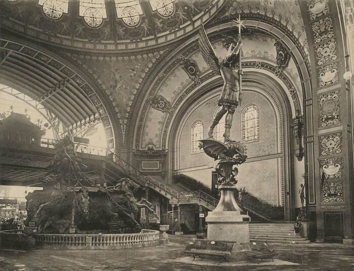 Historic architecture: a grand interior with ornate arches and a striking statue, showcasing old American architectural elegance.