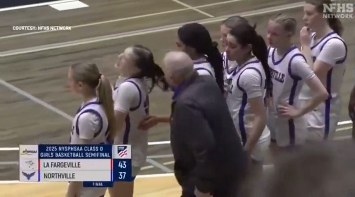 High school basketball coach pulling a girl's hair during a game.