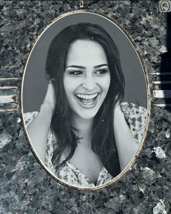 Smiling woman in an oval headstone portrait on granite background.