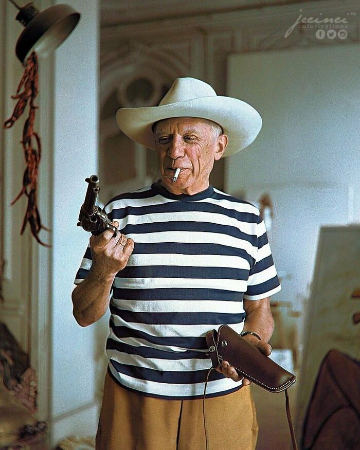 Man in a striped shirt and white hat holding a revolver, evokes historical themes with vintage style.