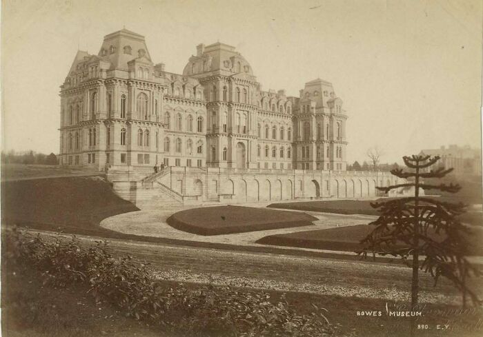 Historic old American architecture featuring a grandiose, ornate building with manicured gardens in the foreground.