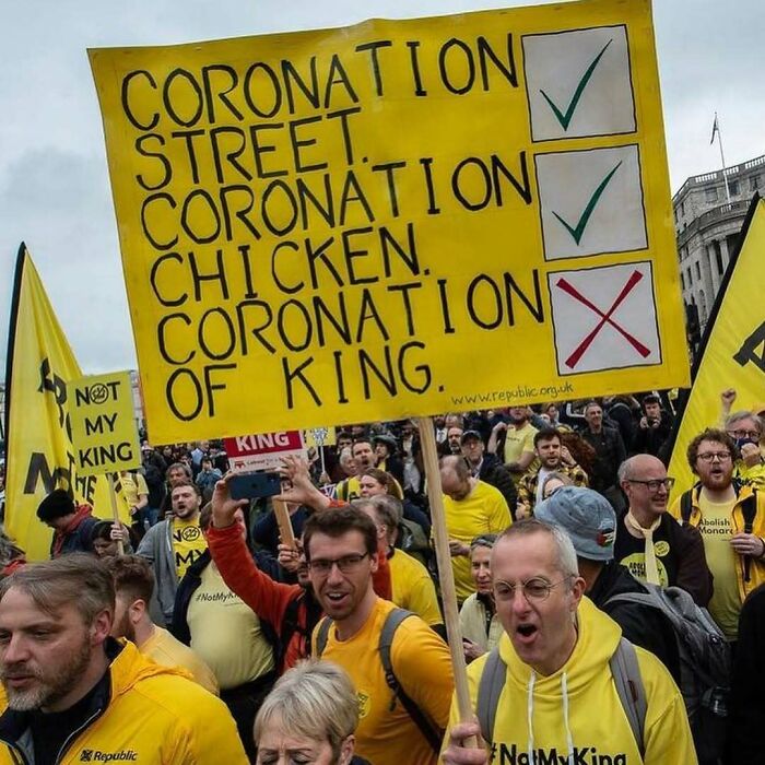 Protesters holding a humorous sign about coronation, emphasizing stuff you should care about in social issues.