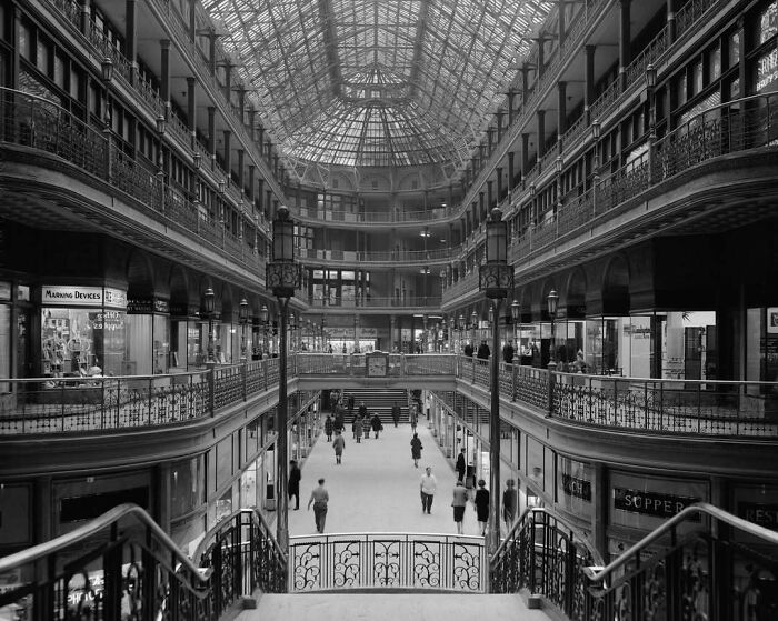 Interior view of a historic American shopping arcade with intricate architectural details and a glass ceiling.