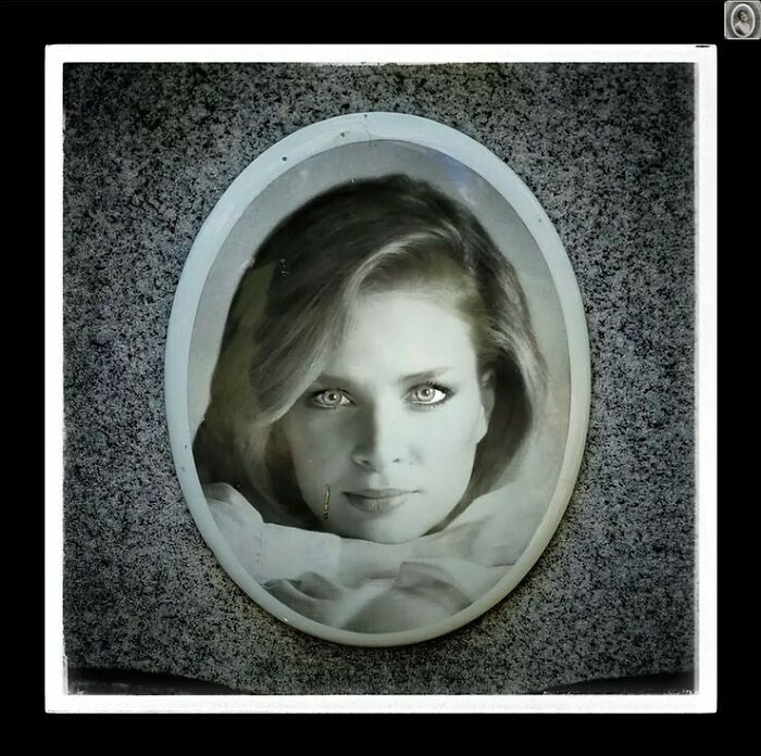 Portrait of a woman's face on a headstone, showcasing a lovely headstone portrait in a grayscale oval frame.