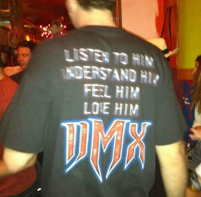 Man wearing a chaotic T-shirt featuring DMX text in a lively setting.