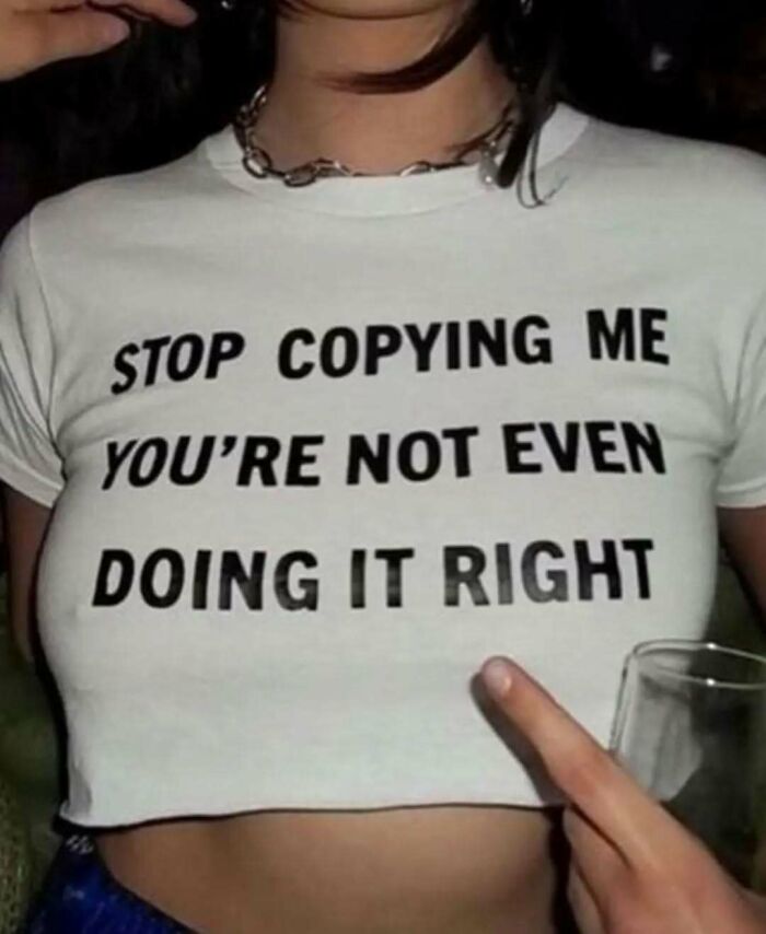 A chaotic t-shirt with the text "Stop copying me you're not even doing it right" in bold black letters.