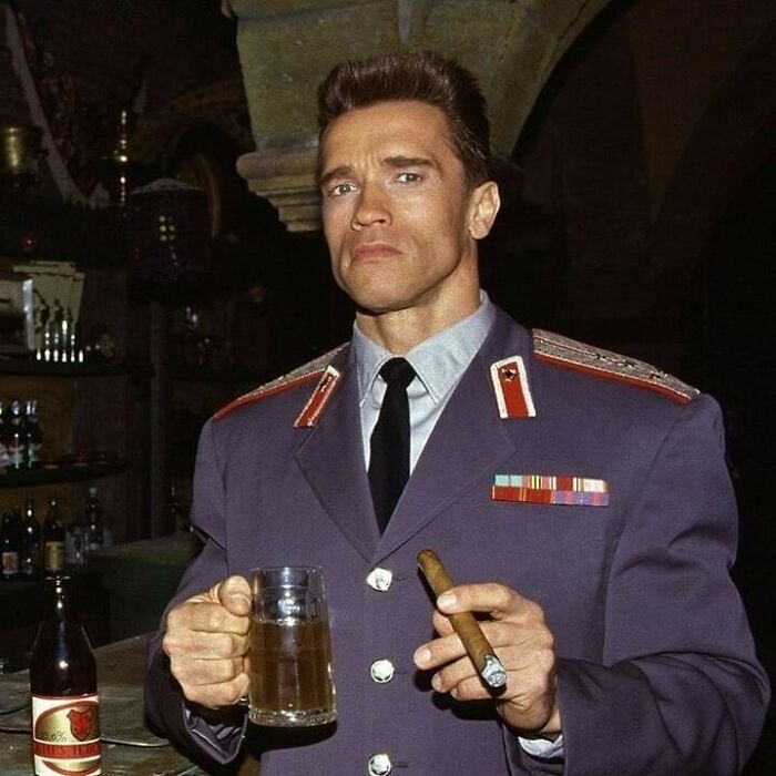 Man in military uniform holding a beer mug and cigar; historical picture highlighting past moments.