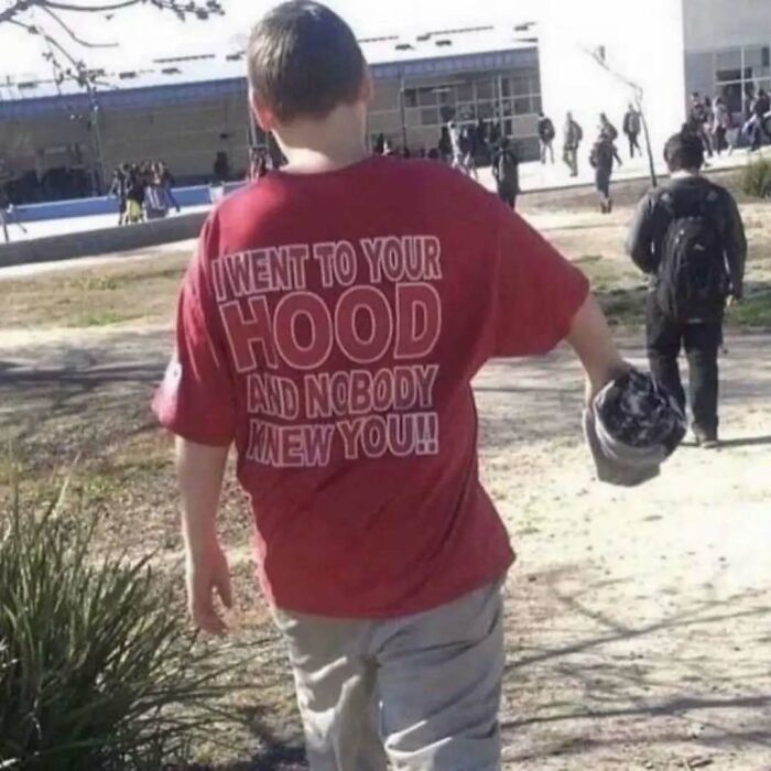 Back view of a person wearing a chaotic T-shirt with bold text.