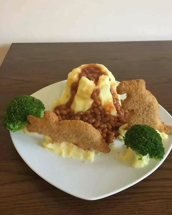 Plato de comida caótica con puré, frijoles, brócoli y figuras empanizadas.