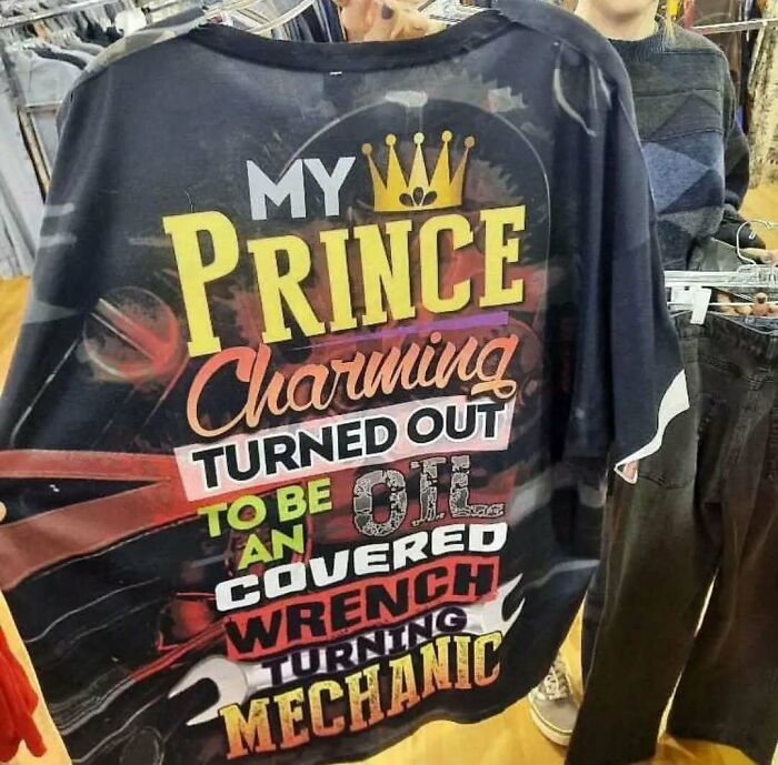 T-shirt with bold text: "My Prince Charming turned out to be an oil-covered wrench-turning mechanic."
