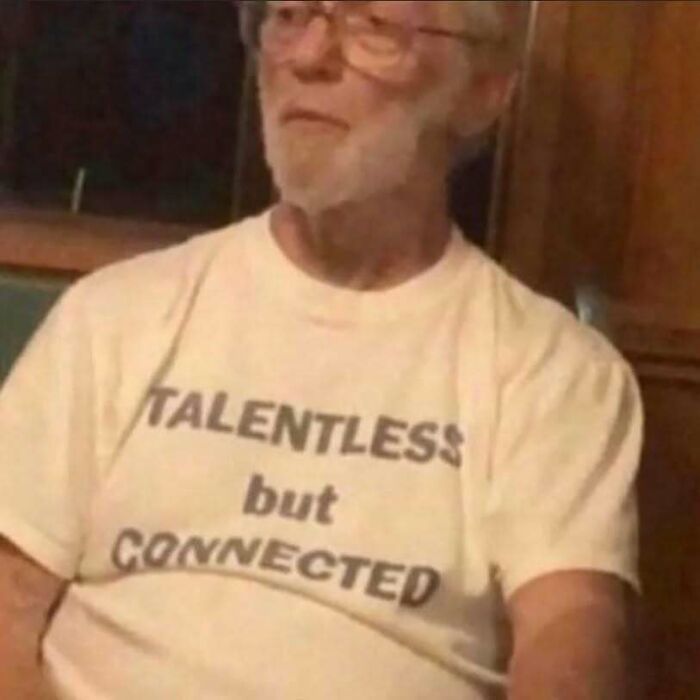 Man in glasses wearing a chaotic T-shirt that reads "TALENTLESS but CONNECTED."