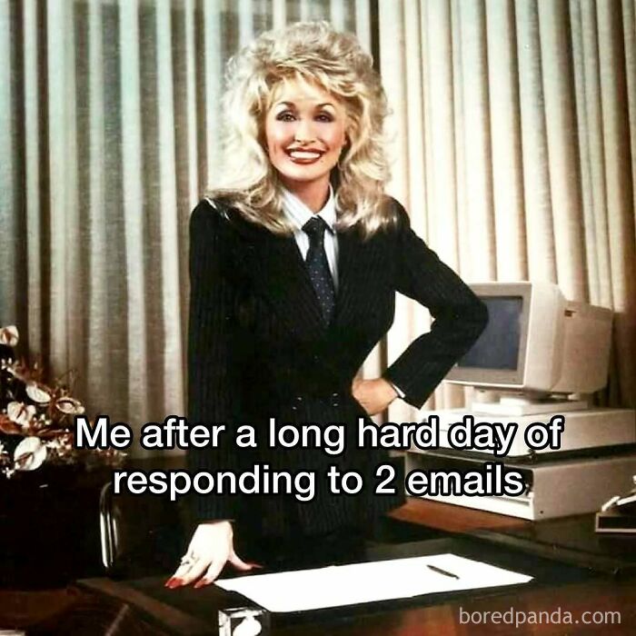 Woman in a suit with 80s hair, standing before an old computer, captioned "Me after a long hard day of responding to 2 emails." Middle class fancy.