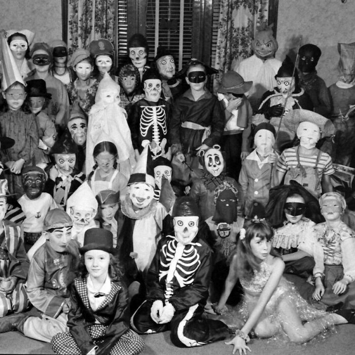 Children in historical costumes and masks, posing indoors, offering a fascinating glimpse into the past.