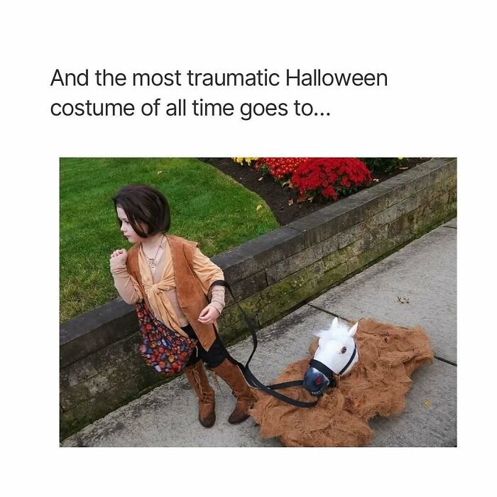 Child in vintage cowboy costume with fake horse on sidewalk, humorous throwback moment.