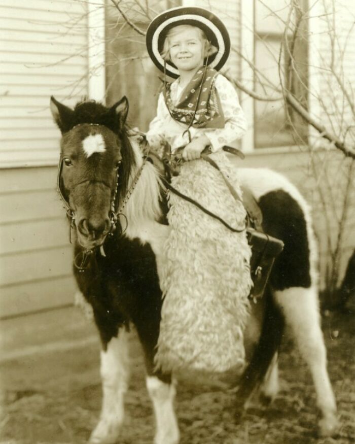 Child in cowboy attire on a pony, offering a historical look into the past.