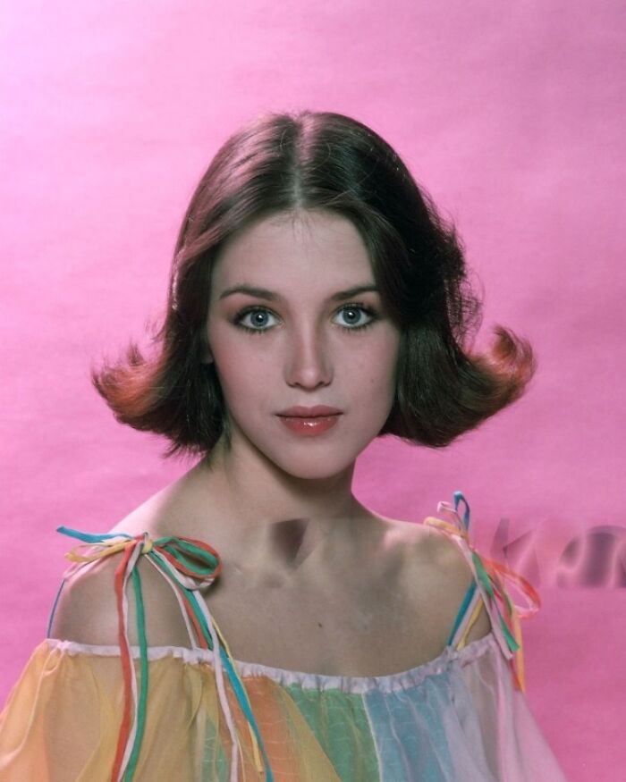 Young woman in colorful dress against a pink background offering a fascinating historical look.