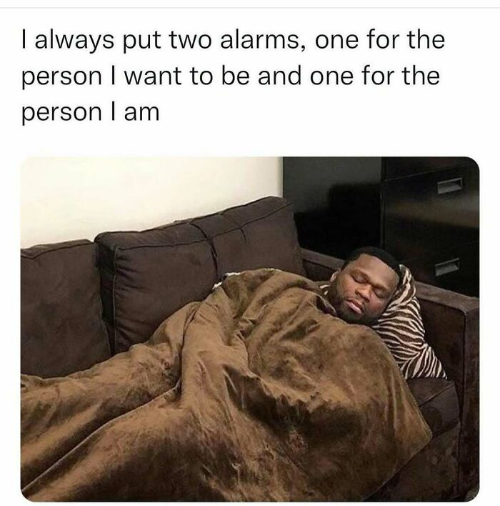A man sleeping on a couch, wrapped in a brown blanket, with text overlay about setting two alarms. Memes for a better day.