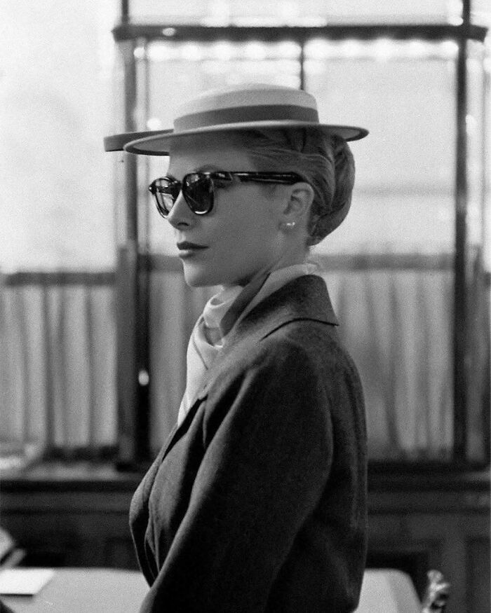 Stylish woman from the past wearing a hat and sunglasses, offering a glimpse into historical fashion trends.
