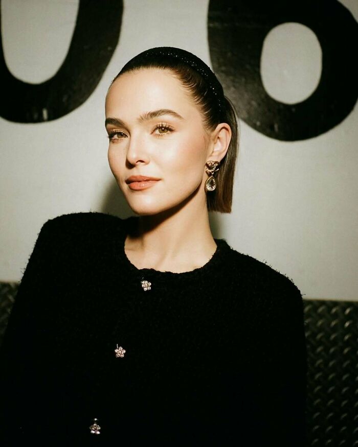A woman with elegant attire and earrings, representing not-self-made-celebs against a stylish backdrop.