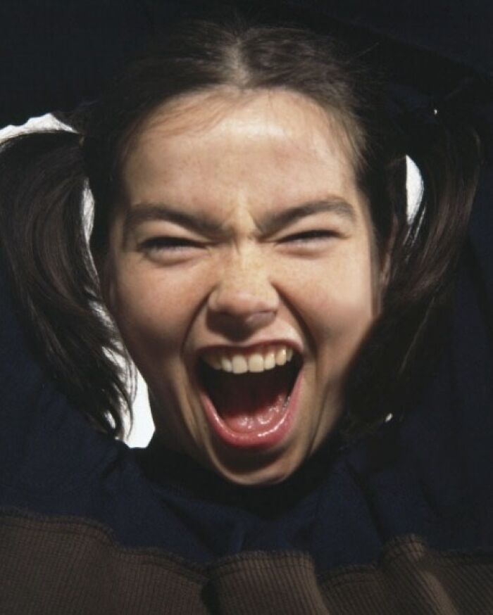 Young woman with pigtails, mouth open wide in excitement, capturing a dynamic historical moment.