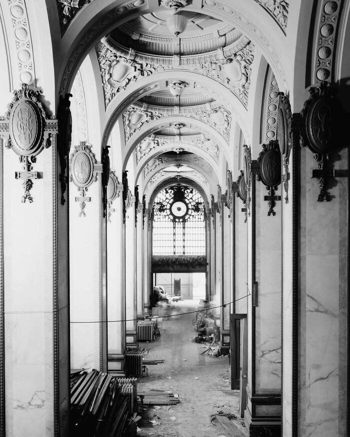 Intricate arches and ornate details in an old American architecture hallway, featuring decorative elements and a grand window.