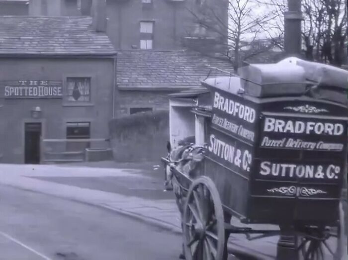 A historical photo of a horse-drawn cart labeled "Bradford" and "Sutton & Co" in front of The Spotted House pub.