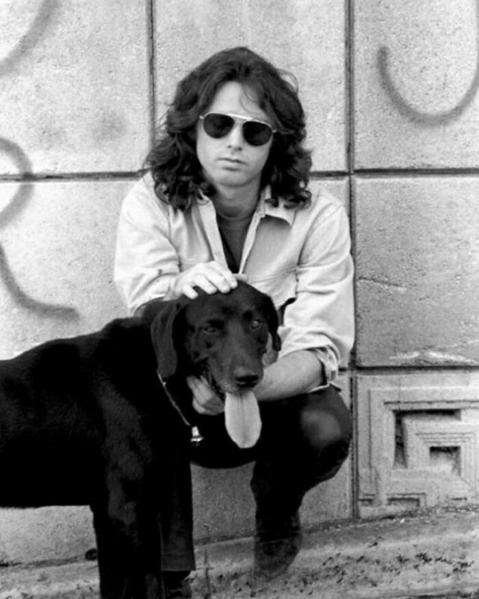 Man in sunglasses and a dog in a historical setting, offering a fascinating look into the past.