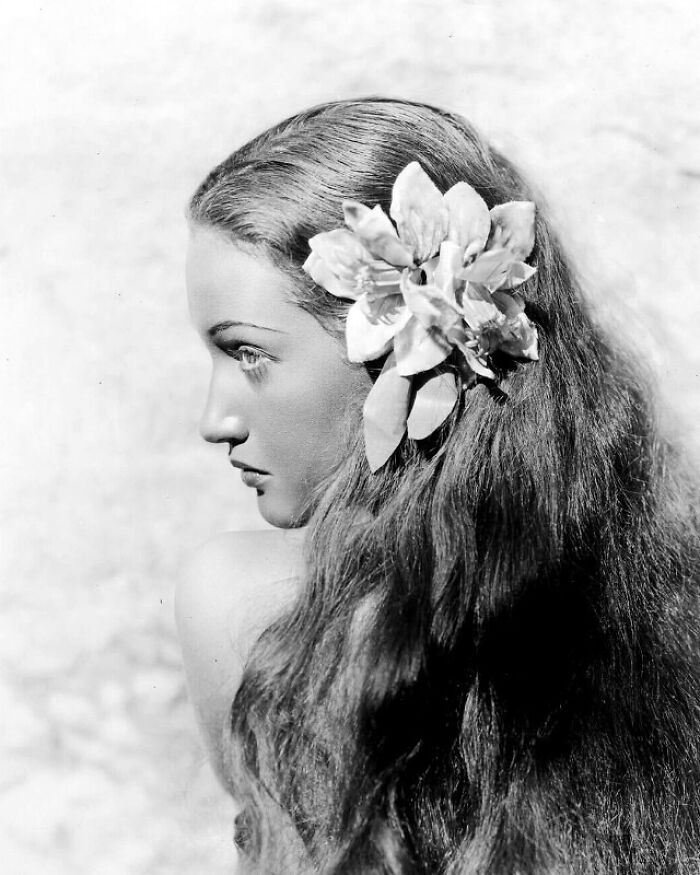 Woman with long hair adorned with a flower, exemplifying historical beauty in a fascinating look into the past.