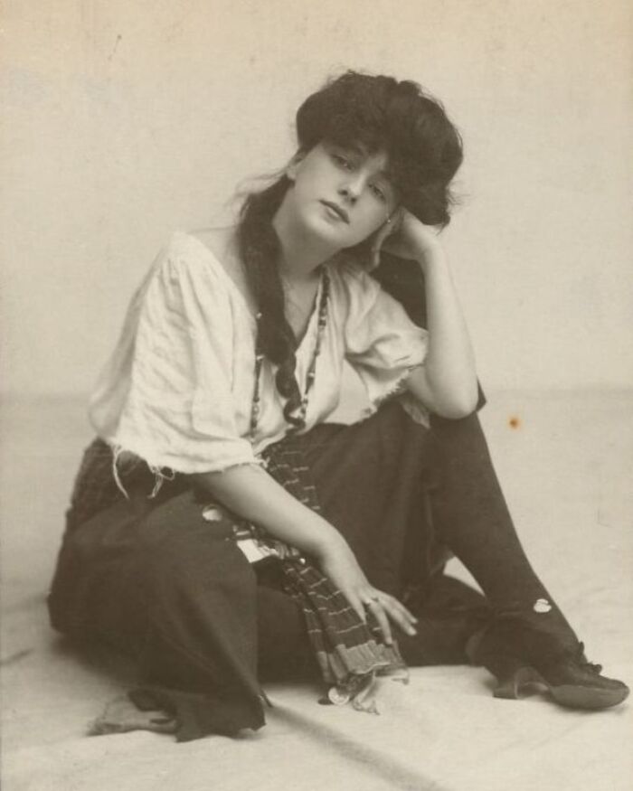 Vintage portrait of a woman sitting, dressed in early 20th-century attire, capturing a fascinating look into the past.