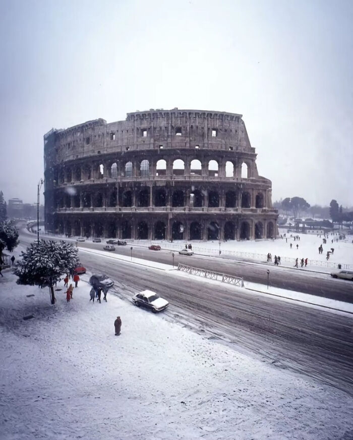 The Colosseum in Rome covered in snow, offering a historical view into the past.